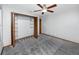 Bright bedroom featuring plush gray carpeting, a ceiling fan, and a closet with bi-fold doors at 11203 Egret Nest Ct, Riverview, FL 33569