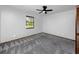 Bright bedroom features soft carpeting, a ceiling fan, and a window letting in natural light at 11203 Egret Nest Ct, Riverview, FL 33569