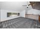 Bright bonus room featuring plush gray carpeting, a ceiling fan, and views of the neighborhood at 11203 Egret Nest Ct, Riverview, FL 33569
