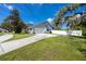 View of the driveway and side of the house, featuring a white fence and a well-maintained lawn at 11203 Egret Nest Ct, Riverview, FL 33569
