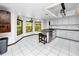 Bright kitchen with white cabinets, a breakfast bar, tile flooring, and multiple windows for natural light at 11203 Egret Nest Ct, Riverview, FL 33569
