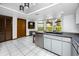 Bright kitchen with stainless steel dishwasher, tile flooring, dual sinks and large windows offering natural light at 11203 Egret Nest Ct, Riverview, FL 33569