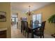 Formal dining room featuring a chandelier, shuttered windows, and adjacent kitchen access at 11501 Cerca Del Rio Pl, Temple Terrace, FL 33617