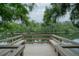 Dock on the water with built-in benches surrounded by lush, green trees and foliage creating a serene outdoor space at 11501 Cerca Del Rio Pl, Temple Terrace, FL 33617
