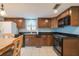 Well-lit kitchen with dark wood cabinets, modern appliances, and tile backsplash at 11501 Cerca Del Rio Pl, Temple Terrace, FL 33617