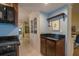 Well-lit kitchen featuring neutral walls, classic cabinetry, tile floors, and black countertops at 11501 Cerca Del Rio Pl, Temple Terrace, FL 33617