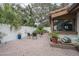 Charming brick patio area with mature trees and inviting outdoor seating at 11501 Cerca Del Rio Pl, Temple Terrace, FL 33617