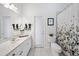 Bright bathroom featuring a white vanity with sink, a toilet, and a shower with a patterned curtain at 11729 Newberry Grove Loop, Riverview, FL 33579