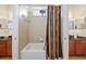 Well-lit bathroom with a tub and shower combination and neutral-colored tiles at 11729 Newberry Grove Loop, Riverview, FL 33579