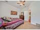 Comfortable bedroom featuring a ceiling fan, carpeted floor, and a glimpse into an attached bathroom at 11729 Newberry Grove Loop, Riverview, FL 33579