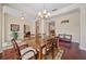 Open dining room with hardwood floors, chandelier, and views into other living spaces at 11729 Newberry Grove Loop, Riverview, FL 33579