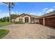 Beautiful home featuring a three-car garage, stone accents, manicured landscaping, and a tile driveway at 11729 Newberry Grove Loop, Riverview, FL 33579