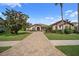 Elegant home featuring manicured lawn and landscaping, stone accents, and a tile driveway at 11729 Newberry Grove Loop, Riverview, FL 33579