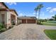 Spacious three-car garage with paneled doors and expansive decorative paver driveway at 11729 Newberry Grove Loop, Riverview, FL 33579