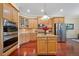 Gourmet kitchen featuring stainless steel appliances, wood cabinetry, and center island at 11729 Newberry Grove Loop, Riverview, FL 33579