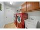 Efficient laundry room featuring modern, red washer and dryer with white utility sink at 11729 Newberry Grove Loop, Riverview, FL 33579