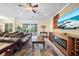Well-lit living room with hardwood floors, ceiling fan, and sliding glass doors to the outdoor living space at 11729 Newberry Grove Loop, Riverview, FL 33579