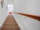 Carpeted staircase with a wooden handrail, leading to the next level of the house at 11729 Newberry Grove Loop, Riverview, FL 33579