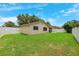 Expansive backyard featuring a pristine white fence, beautiful green grass, and manicured landscaping at 12156 Meadowbrook Ln, Largo, FL 33774