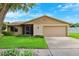 Inviting single-story home featuring an attached garage, screened porch, and manicured front lawn at 12156 Meadowbrook Ln, Largo, FL 33774