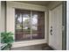 Home's exterior featuring a window with blinds and a decorative front door at 12156 Meadowbrook Ln, Largo, FL 33774