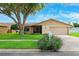Charming single-story home with a well-manicured lawn, large tree, and attached two-car garage at 12156 Meadowbrook Ln, Largo, FL 33774