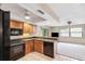 Kitchen features light wood cabinetry and black appliances at 12156 Meadowbrook Ln, Largo, FL 33774