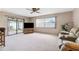 Spacious living room features sliding glass doors to the patio, carpet, and a ceiling fan at 12156 Meadowbrook Ln, Largo, FL 33774