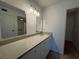 Bathroom featuring double mirrors, a long vanity with ample counter space, and access to shower at 12300 Vonn Rd # 9105, Largo, FL 33774