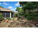 Backyard view highlighting the home’s exterior with the open patio featuring lush landscape at 12411 Talpa St, Spring Hill, FL 34608