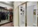Bright white shower stall with glass doors adjacent to a walk in closet and organizing system at 12411 Talpa St, Spring Hill, FL 34608