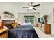 This bedroom features a ceiling fan and outdoor views through a large window at 12411 Talpa St, Spring Hill, FL 34608
