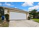 Spacious two car garage with a concrete driveway and landscaped yard at 12411 Talpa St, Spring Hill, FL 34608