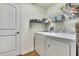 Efficient laundry room with modern washer and dryer, wire shelving for organized storage at 12411 Talpa St, Spring Hill, FL 34608