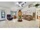 Bright living room featuring tile floors, a ceiling fan, and comfortable leather furniture at 12411 Talpa St, Spring Hill, FL 34608