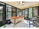 Bright sunroom with tile flooring and ample windows offering views of the lush outdoor space at 12411 Talpa St, Spring Hill, FL 34608