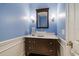 A stylish bathroom features a vessel sink, sconces, and wainscoting at 125 Belleview Blvd # 503, Belleair, FL 33756