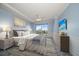 Well-lit bedroom featuring light blue walls, decorative molding, a large window, and stylish furnishings at 125 Belleview Blvd # 503, Belleair, FL 33756