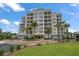 Luxury waterfront condo building featuring multiple balconies, lush landscaping and porte-cochere entrance at 125 Belleview Blvd # 503, Belleair, FL 33756