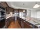 Bright kitchen with stone countertops and backsplash, dark cabinets, and stainless steel appliances at 125 Belleview Blvd # 503, Belleair, FL 33756