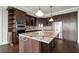Kitchen features dark wood cabinetry, stainless appliances, granite countertops, and a large center island at 125 Belleview Blvd # 503, Belleair, FL 33756
