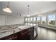 Open kitchen with granite island, stainless steel dishwasher, and view to adjacent rooms with floor-to-ceiling windows at 125 Belleview Blvd # 503, Belleair, FL 33756