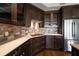 Close-up of a modern kitchen with dark cabinets, stone backsplash and countertops, and stainless steel appliances at 125 Belleview Blvd # 503, Belleair, FL 33756