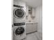 A convenient laundry area with stackable washer and dryer and utility sink at 125 Belleview Blvd # 503, Belleair, FL 33756