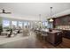 Spacious living room with open kitchen, large windows, hardwood floors, and modern furnishings at 125 Belleview Blvd # 503, Belleair, FL 33756