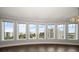 Empty living room featuring large windows offering cityscape views and dark hardwood floors at 125 Belleview Blvd # 503, Belleair, FL 33756