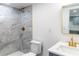 A well-lit bathroom features a walk-in shower with marble tile, gold fixtures, a vanity, and a toilet at 1328 Waikiki Way, Tampa, FL 33619