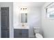 A well-lit bathroom with a vanity, toilet, gold fixtures, and a mirror offers comfort and style at 1328 Waikiki Way, Tampa, FL 33619