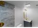 A well-lit bathroom features a walk-in shower with marble tile, gold fixtures, a vanity, and a toilet at 1328 Waikiki Way, Tampa, FL 33619