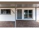 Charming entryway featuring a gray door, a covered porch, and brick pavers at 1328 Waikiki Way, Tampa, FL 33619